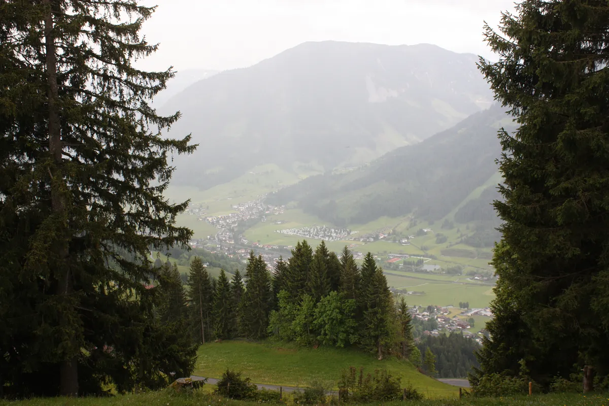 Blick von einem bewaldeten Berghang auf Brixen im Thale