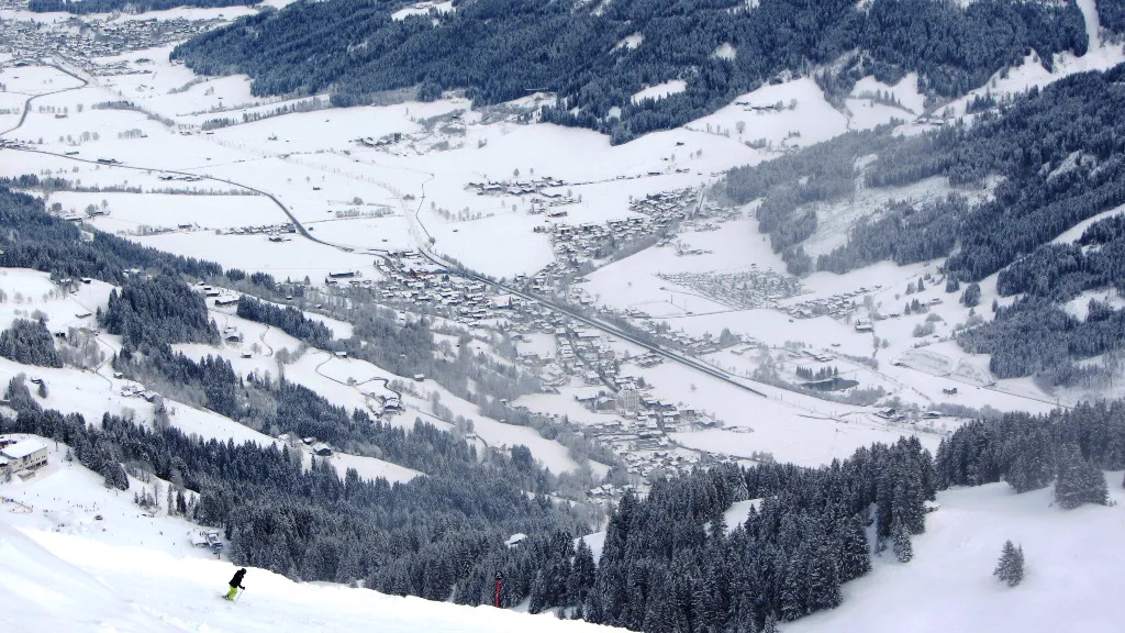 Verschneites Brixental mit Skipiste und Skifahrer